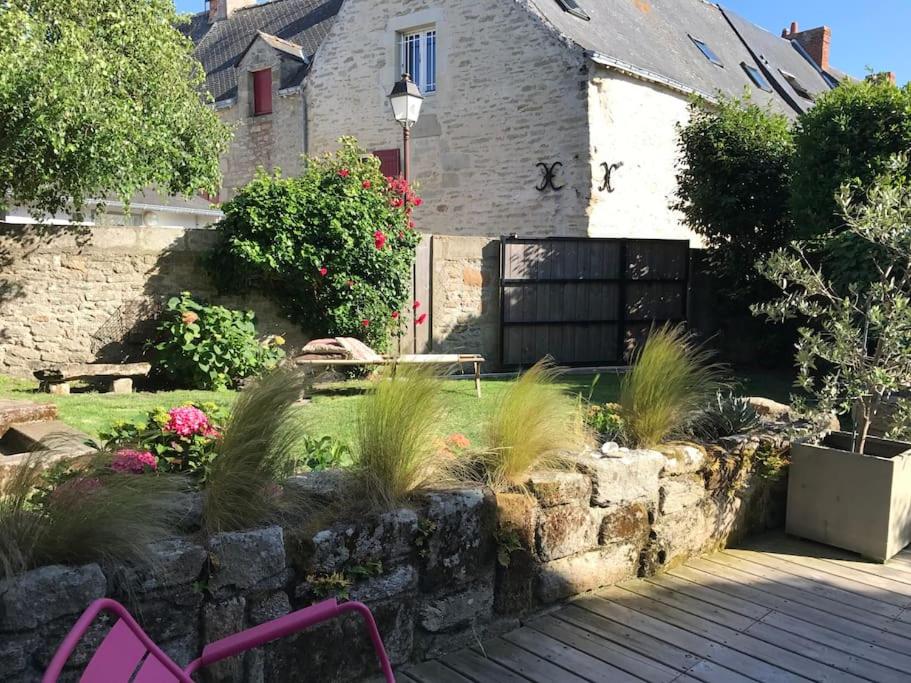 un jardin avec des plantes devant une maison dans l'établissement Maison de charme, jardin clos sud, terrasse, 2 minutes plages, au cœur du village de Piriac, 4 chambres 2 SDB., à Piriac-sur-Mer