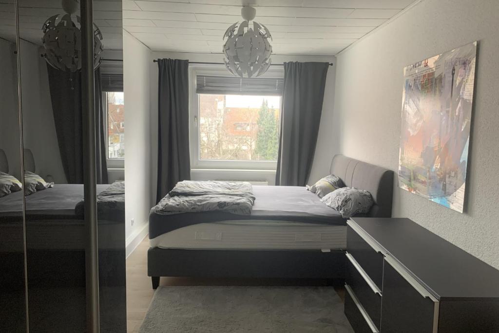 um quarto com uma cama, um espelho e uma janela em Private Apartment em Hanôver