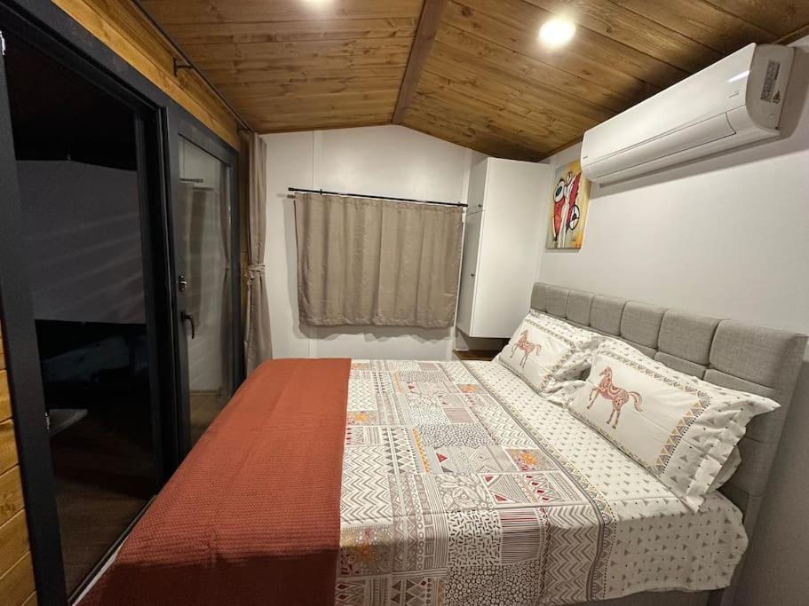 ein Schlafzimmer mit einem Bett in einem winzigen Haus in der Unterkunft Tiny House Bungalow - Pool, Jacuzzi, Winter Garden in Izmir