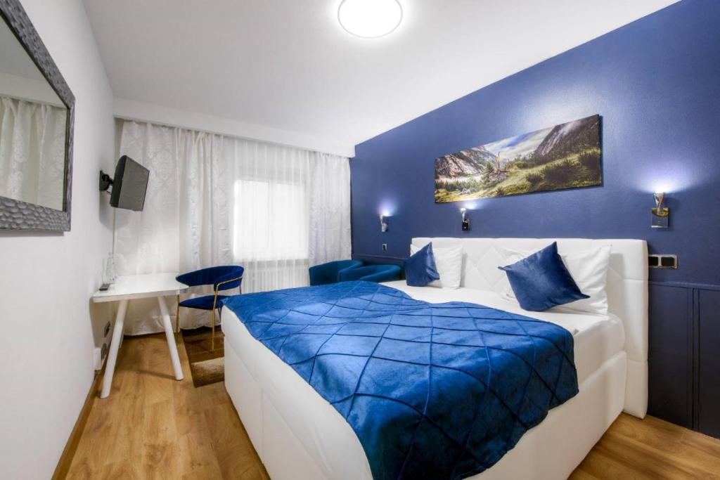 ミュンヘンにあるホテル リヴォリの青と白のベッドルーム(ベッド1台、デスク付)
