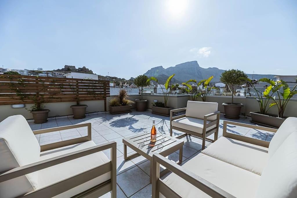 un patio avec des chaises et une table sur le toit dans l'établissement Archangelos SKY Garden Apartment, à Archangelos