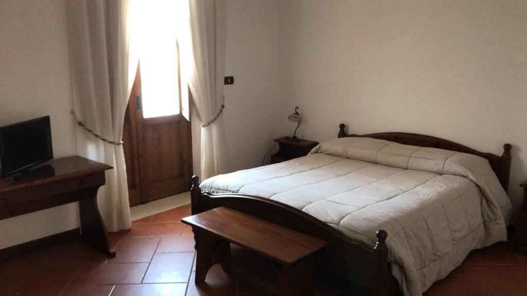 a bedroom with a bed and a television and a window at Agriturismo Genovesi in Alvignano