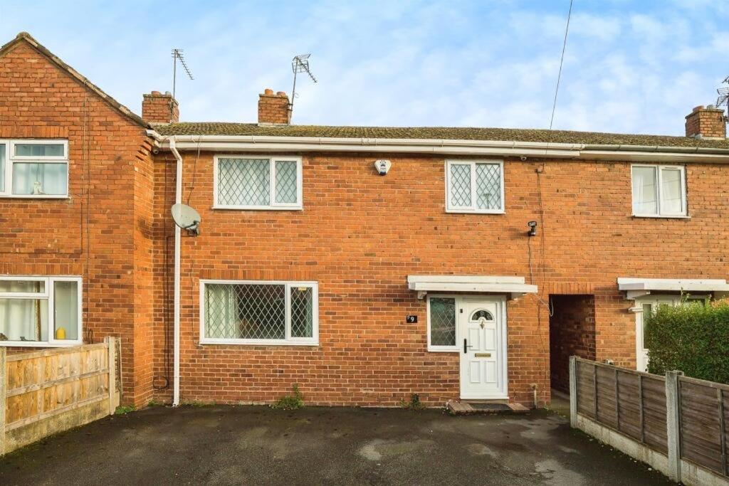 ein rotes Backsteinhaus mit einer weißen Tür in der Unterkunft Ideal Abode Greenfields in Chester