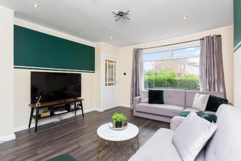 a living room with a couch and a tv at Stylish 3 bed Edinburgh Abode - Parking and Garden in Edinburgh