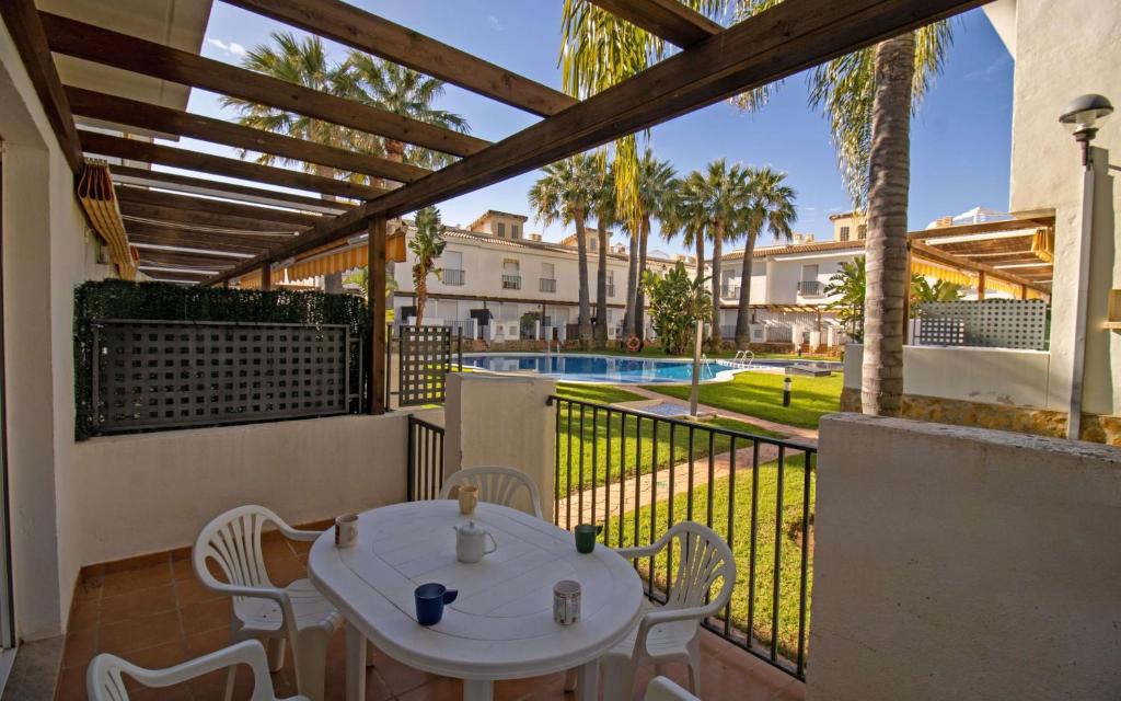 d'une terrasse avec une table et des chaises sur un balcon. dans l'établissement Adosado con jardin y piscina Palm Beach 86 ALBERT VILLAS, à Alcossebre