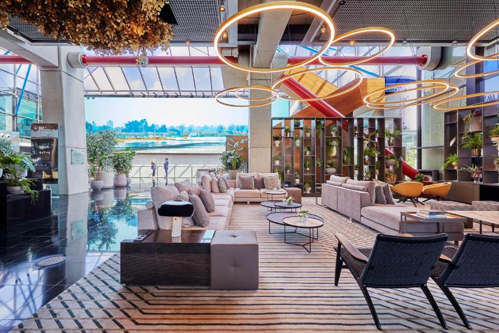 a lobby with couches and chairs in a building at Hyatt Regency Barcelona Tower in Hospitalet de Llobregat