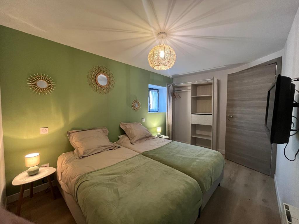a bedroom with a large bed and a television at Belle villa avec spa et sauna in Tayrac