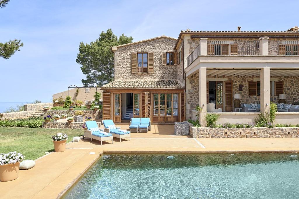Villa Can Miquelet Deia في دِيّا: بيت فيه مسبح قدام بيت