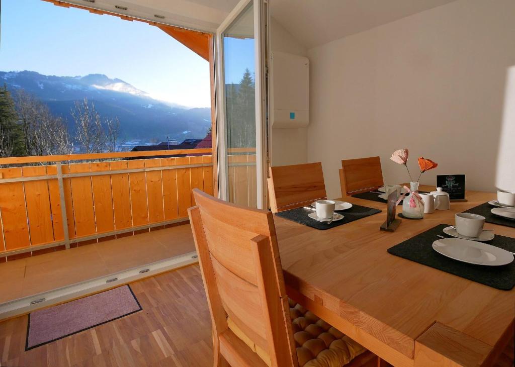 a dining room with a table and a large window at Ferienwohnungen beim Sommermader in Nesselwang