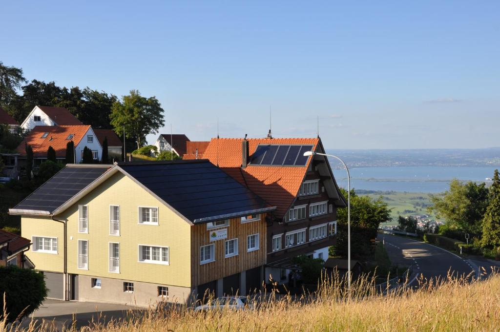 ein Haus mit Sonnenkollektoren auf dem Dach in der Unterkunft Gästehaus Eisenhut in Walzenhausen