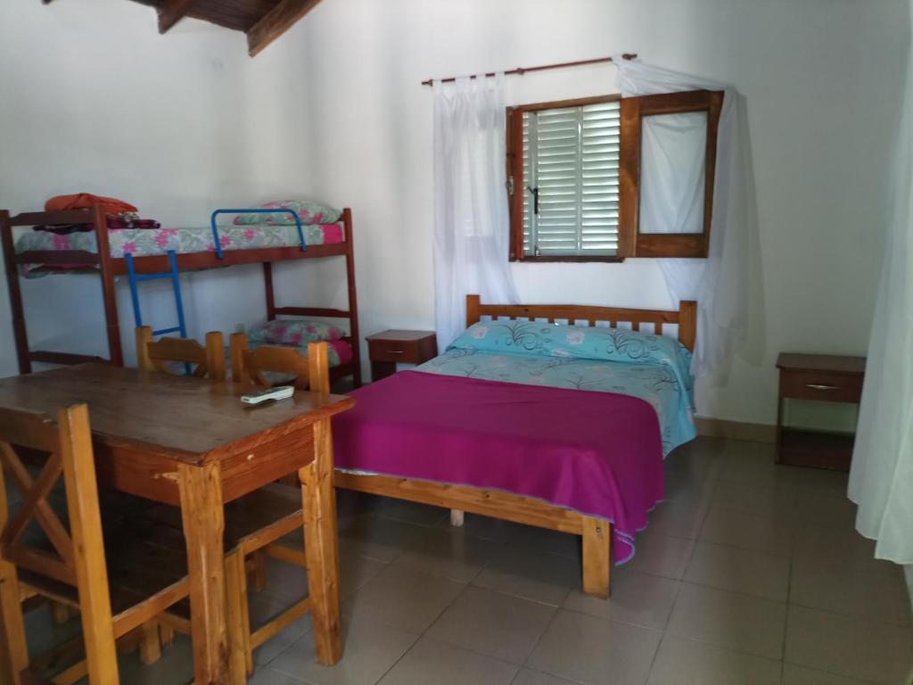 1 dormitorio con cama, mesa y literas en Alojamiento Lo de Bocha en Gualeguaychú