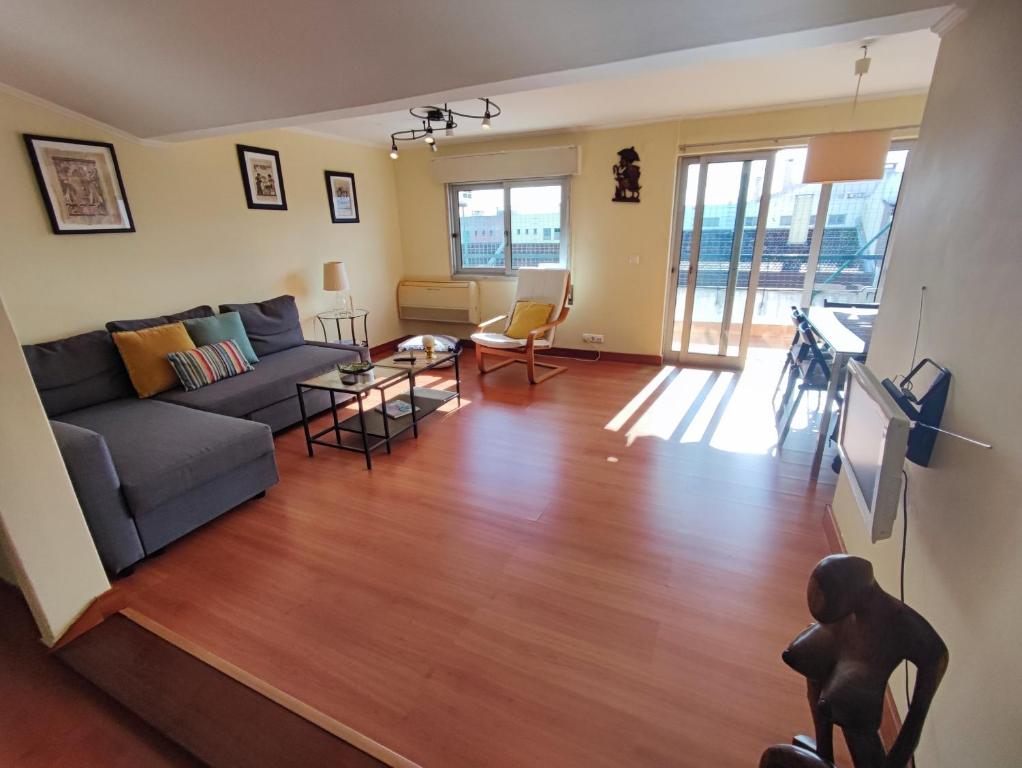 uma sala de estar com um sofá e uma mesa em Oeiras, 2 bedroom apartment w balcony and barbecue next to Parque dos Poetas em Oeiras