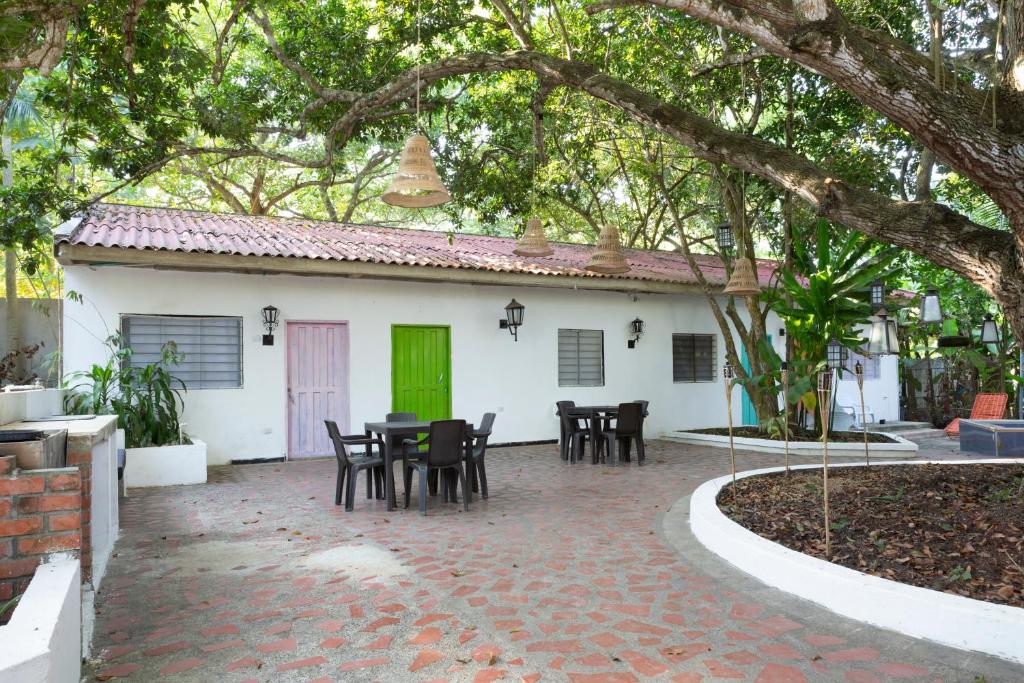 un patio frente a una casa blanca con una puerta verde en Hotel Villa Ivel, en Turbaco