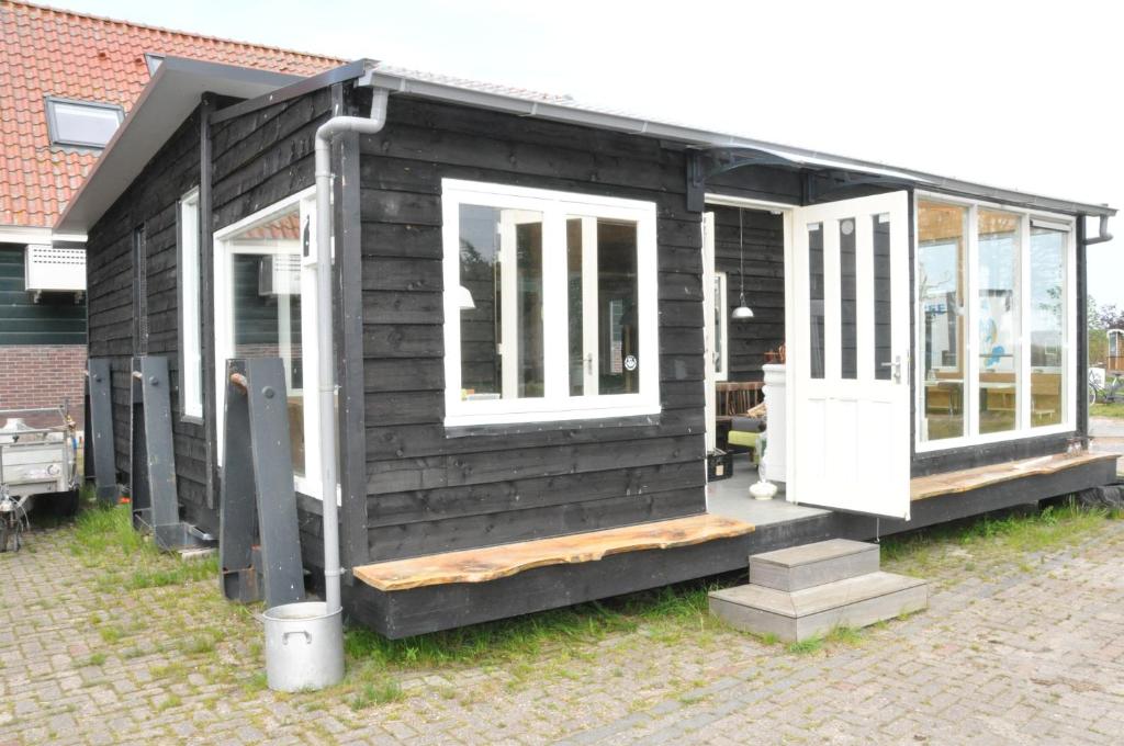 a black house with white doors and windows at Large cottage on sheepfarm in Amsterdam