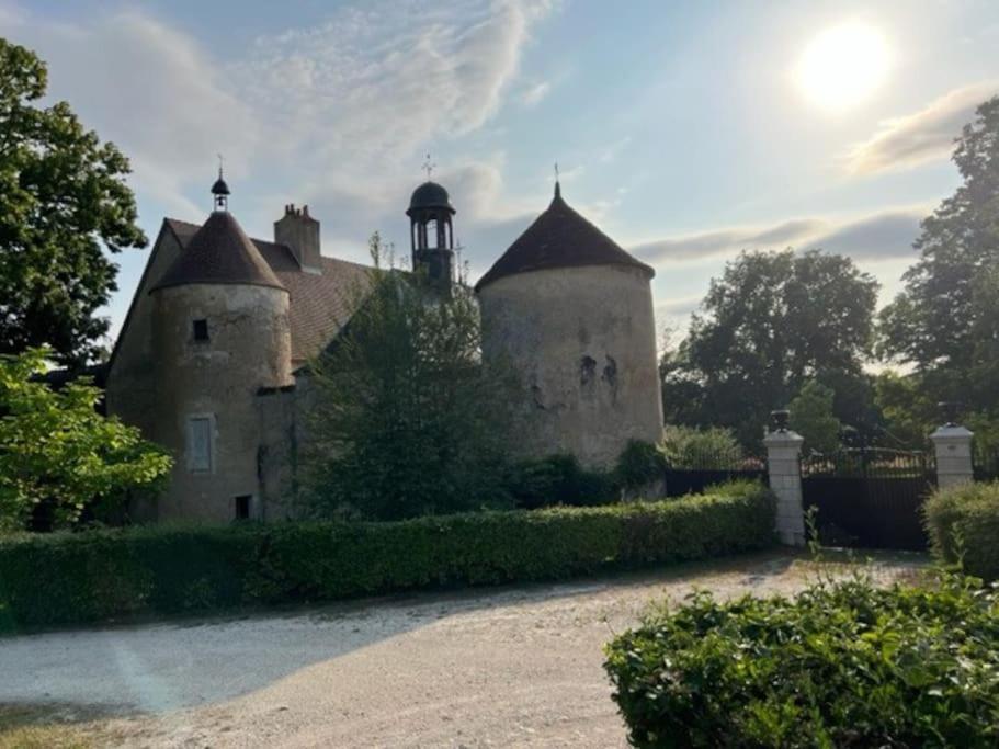un vieux château avec une tour en haut dans l'établissement Logement Château de Villeneuve, à Saint-Pardoux
