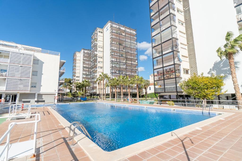 uma piscina numa cidade com edifícios altos em Apartamento perfecto en Sitges em Sitges