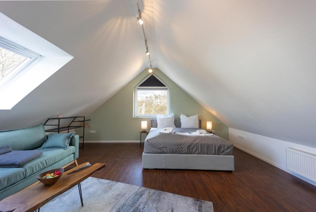 a attic bedroom with a bed and a couch at HejU- Haus im Grünen in Rosengarten