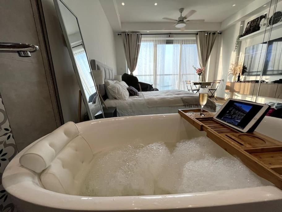 a bath tub with a laptop sitting in it at Luxury Beachfront Studio Apartment Marjan Island in Ras al Khaimah