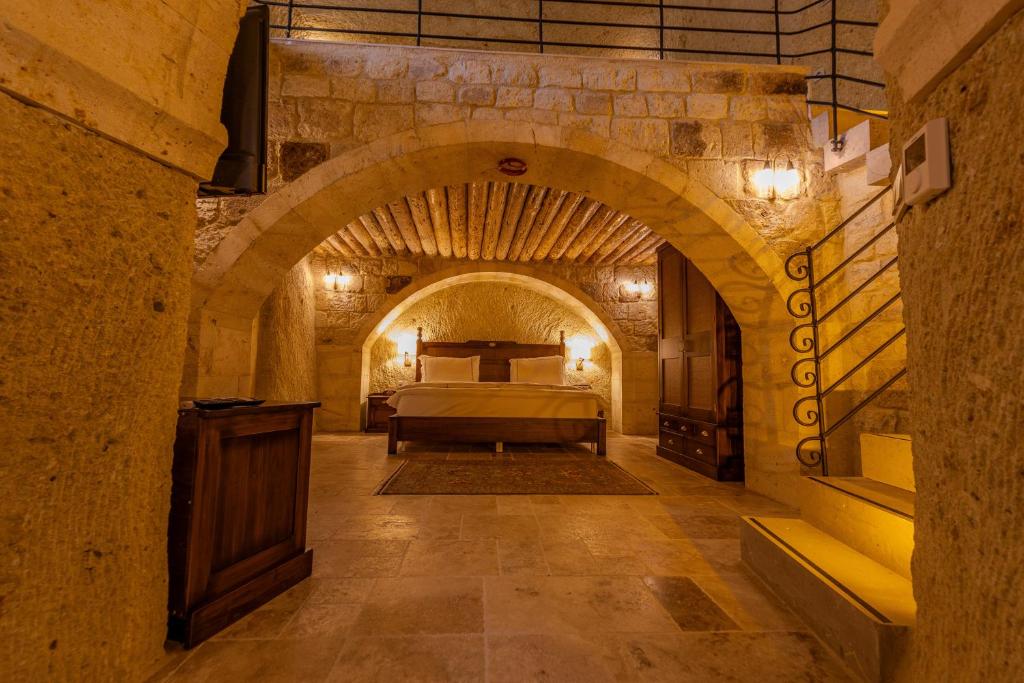 1 dormitorio con 1 cama en un edificio de piedra en Seraphim Cave Suites & SPA en Urgup