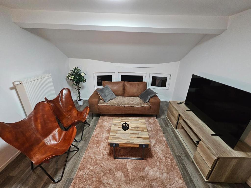uma sala de estar com um sofá e uma televisão de ecrã plano em Appartement Luna em Dinant