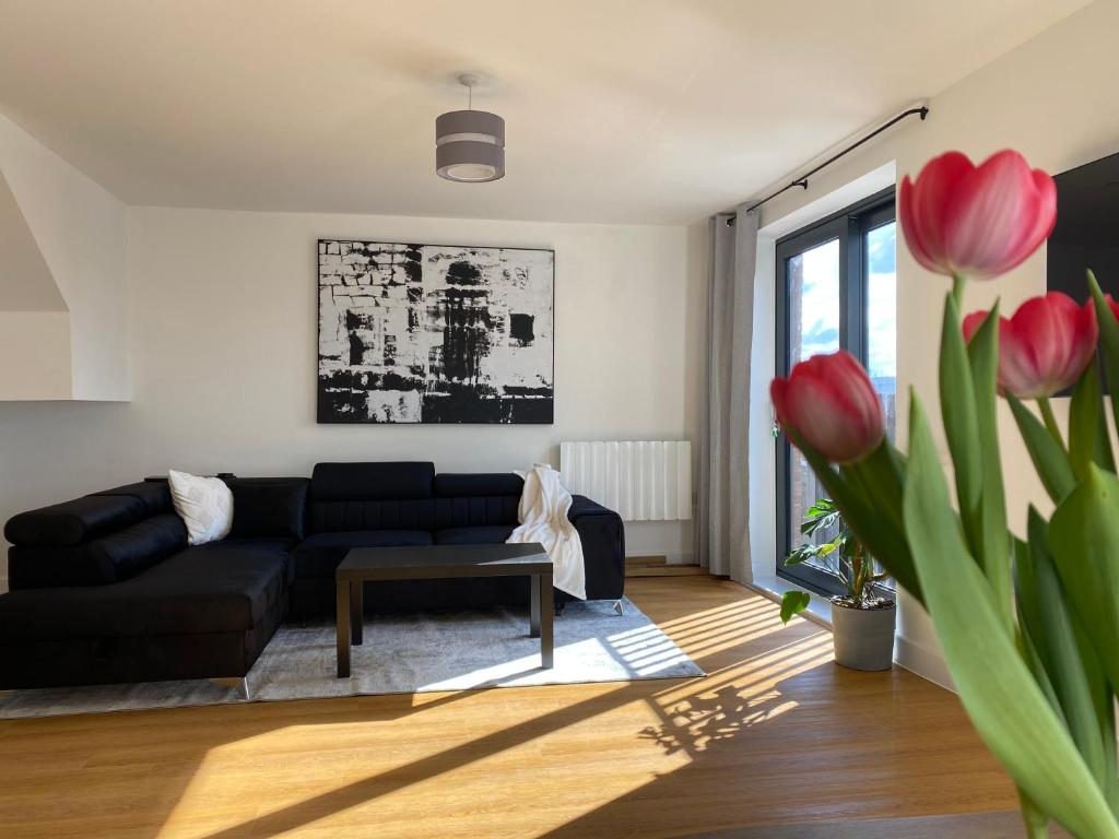 uma sala de estar com um sofá preto e uma mesa em Beautiful Penthouse In Bristol - new em Bristol