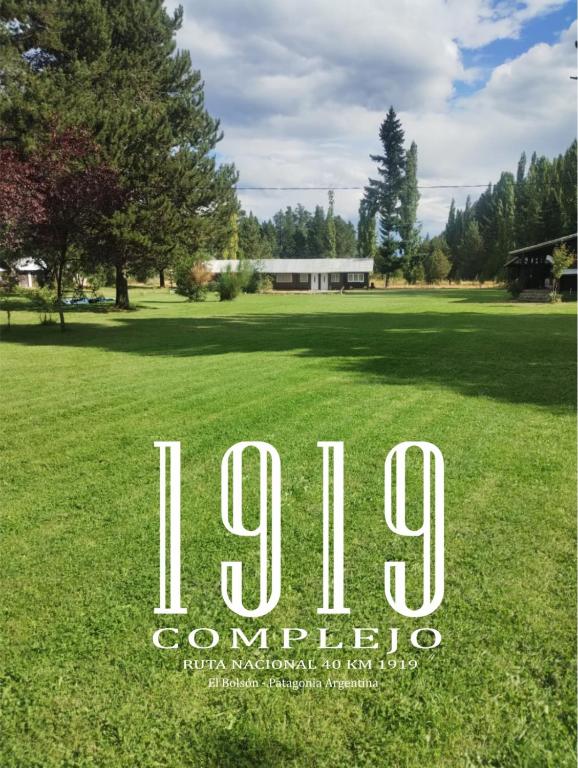 a sign that says in a field of grass at Complejo 1919 in El Bolsón