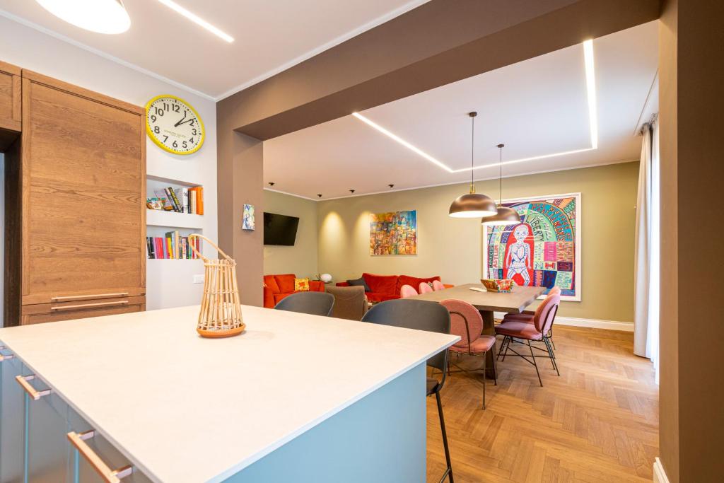 a kitchen and dining room with a clock on the wall at Casa Alexandra - Luxury & Design in Castellammare del Golfo
