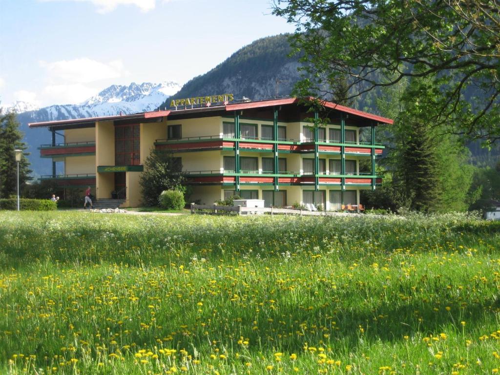 a building with a field in front of it at Appartements Achensee in Maurach