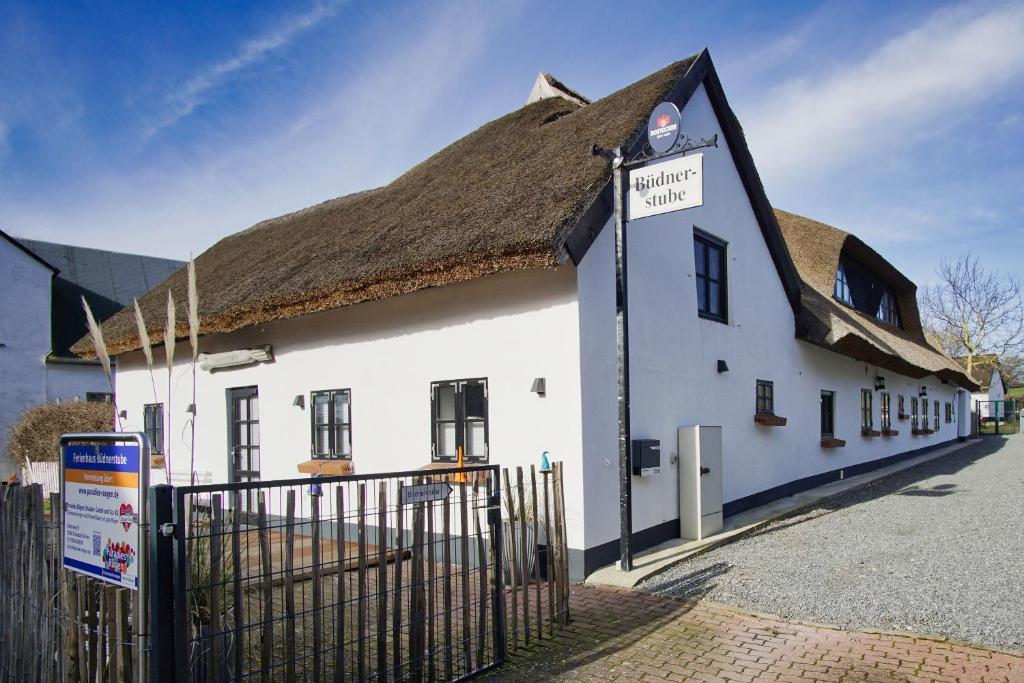 a white building with a thatched roof at nah am Meer, ruhige Lage, gratis Nutzung vom AHOI Erlebnisbad und Sauna in Sellin - Haus Büdnerstube FeWo 2 in Middelhagen