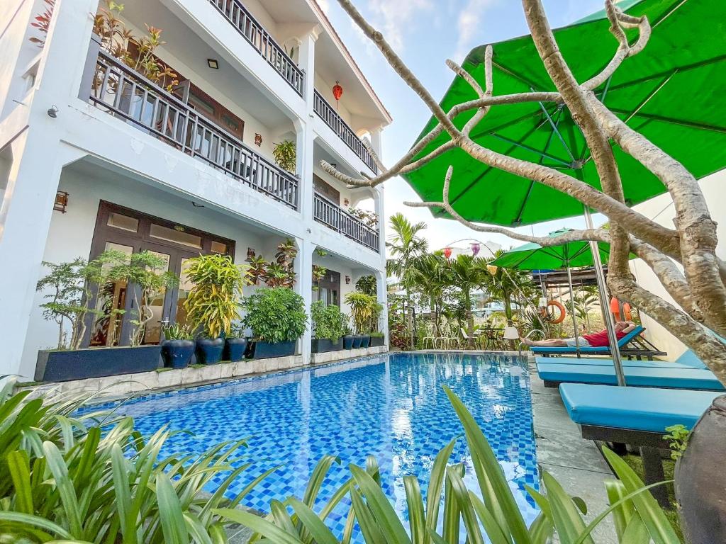 un hotel con piscina frente a un edificio en Trendy Life Villa en Hoi An