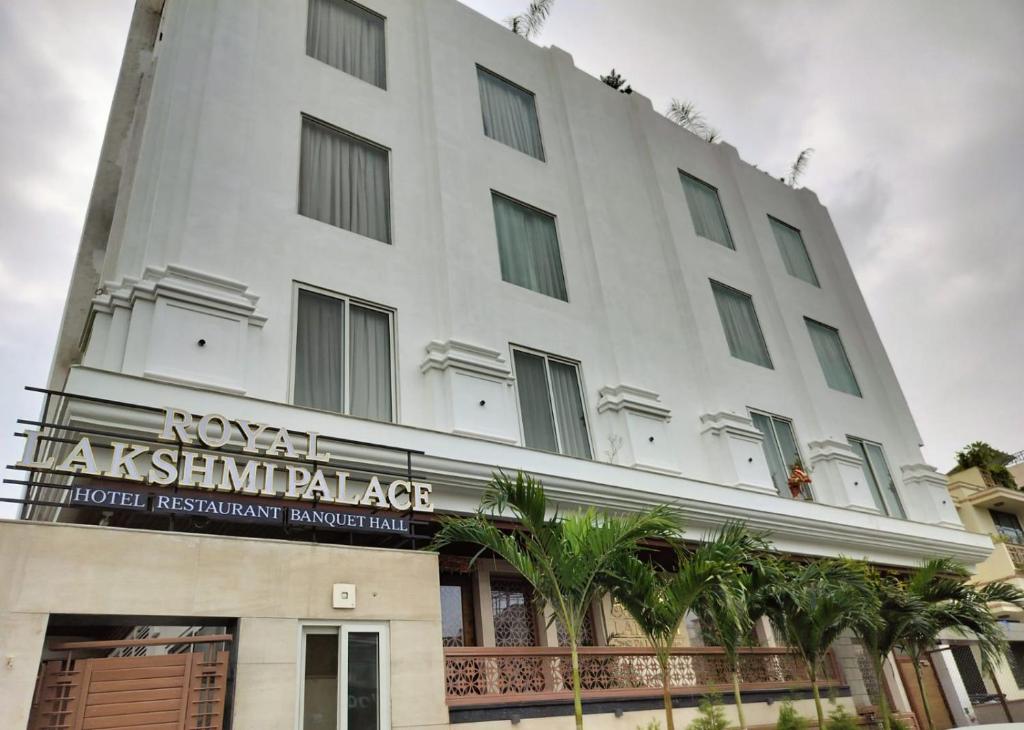 ein weißes Gebäude mit einem Schild davor in der Unterkunft Hotel Royal Lakshmi Palace in Jaipur