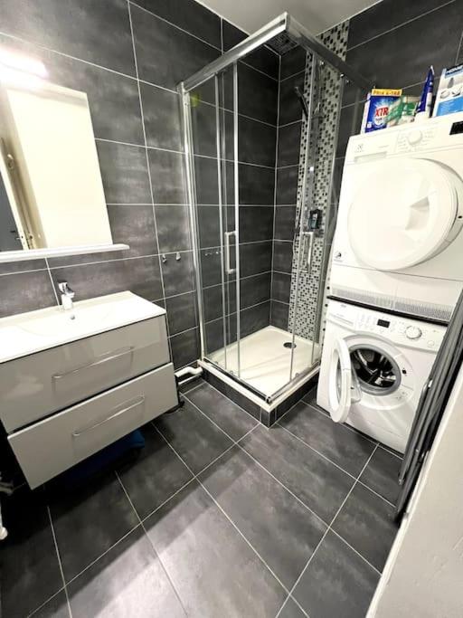 a bathroom with a washing machine and a shower at Shiny Compiègne Logement Entier in Compiègne