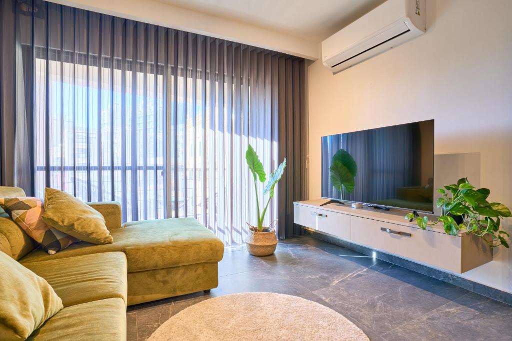 a living room with a couch and a flat screen tv at Garden View 9 - Two Bedroom Apartment in St. Julianʼs