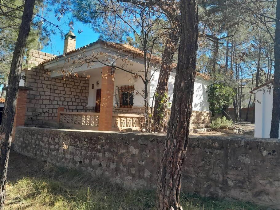 a house with a stone wall and a tree at La Casita de Nicolás in Mora de Rubielos