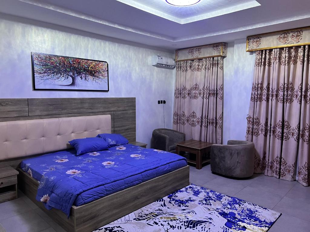 a bedroom with a bed and a chair and a table at Delight Bay Shortlet in Lekki