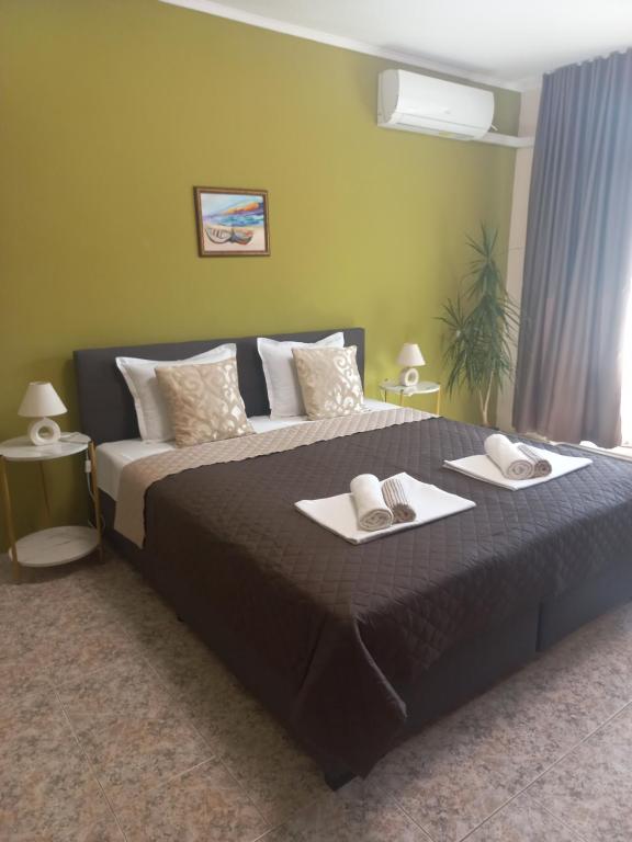 1 dormitorio con 1 cama grande y 2 toallas en Guest House Dani, en Pomorie