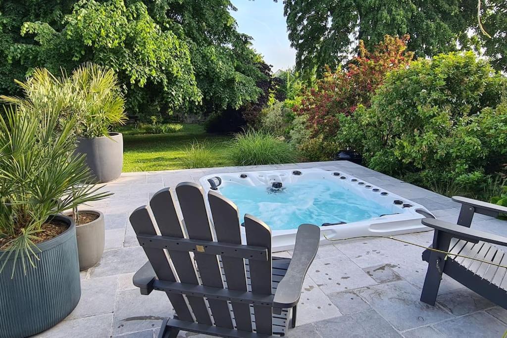 einen Whirlpool auf einer Terrasse mit 2 Stühlen in der Unterkunft Villa 35 minutes Paris in Saint-Prix