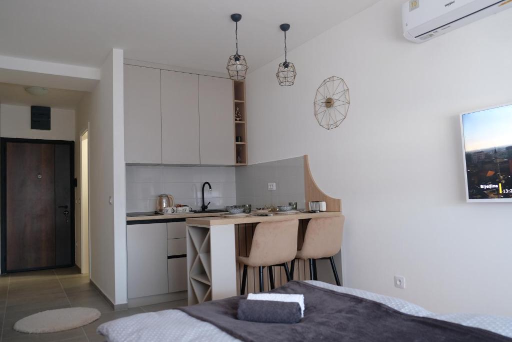 ein Schlafzimmer mit einem Bett und eine Küche mit einer Theke in der Unterkunft Apartman 33 in Banja Luka