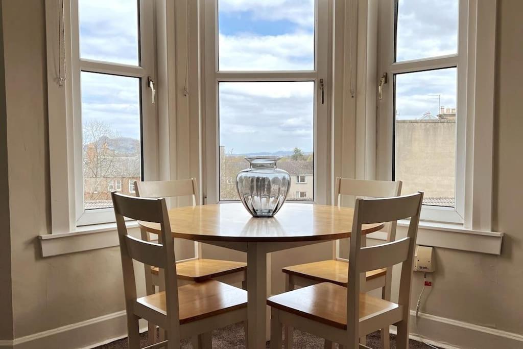 um vaso sentado numa mesa numa sala com janelas em Stylish & Central Flat in Edinburgh. Free Parking em Edimburgo