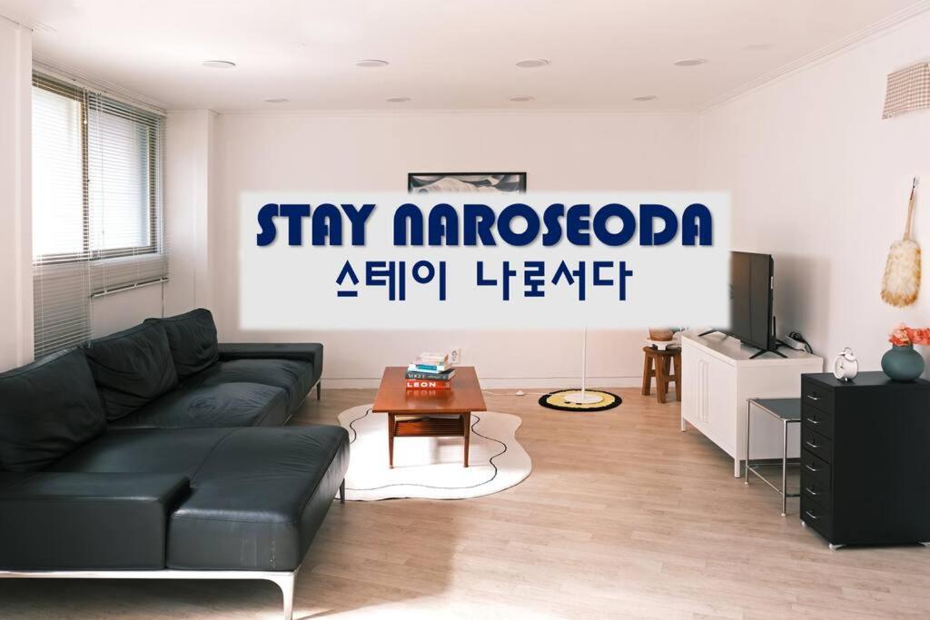 a living room with a black couch and a tv at Stay Naroseoda in Incheon