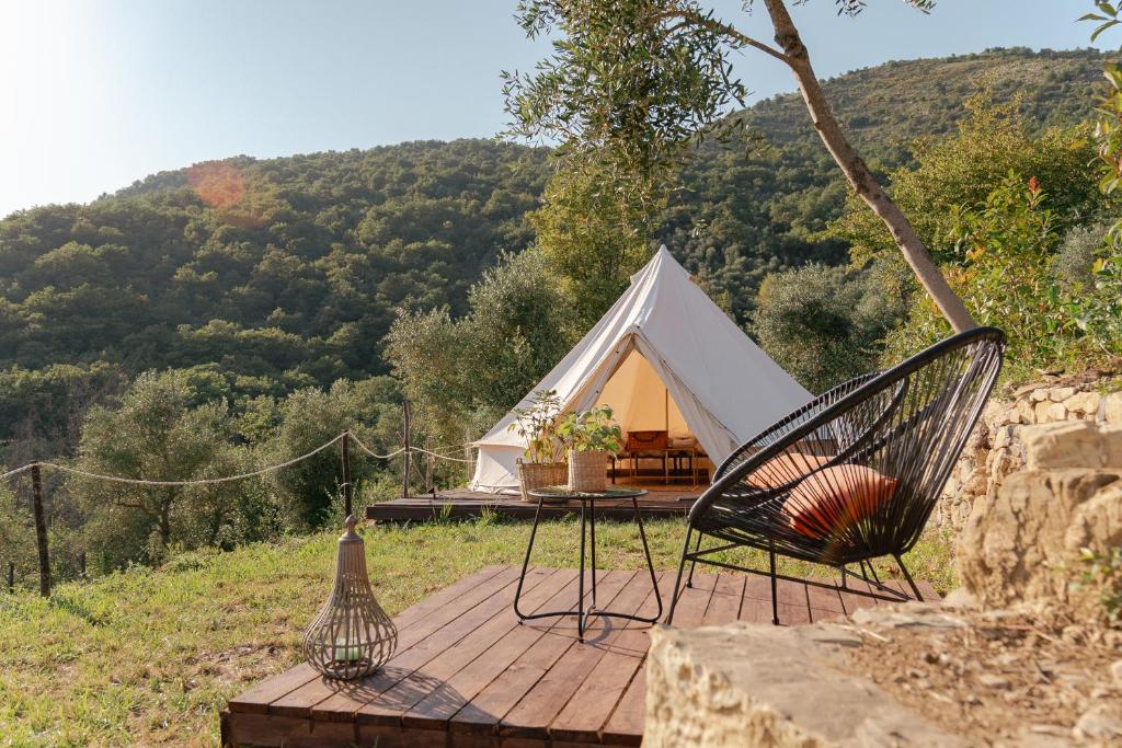 a tent with a table and chairs on a wooden deck at tendù family in Chiusanico