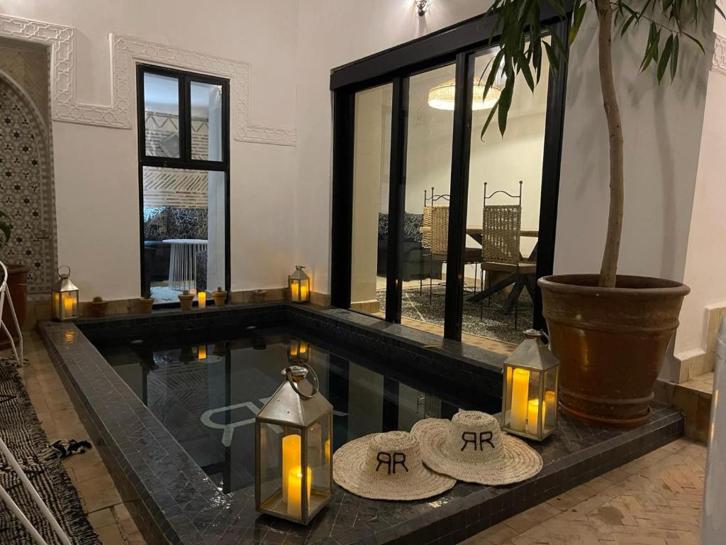 a swimming pool with candles in a living room at Riad rénové en 2023, idéalement situé, 5 minutes de la place Jemaa El Fna in Marrakesh