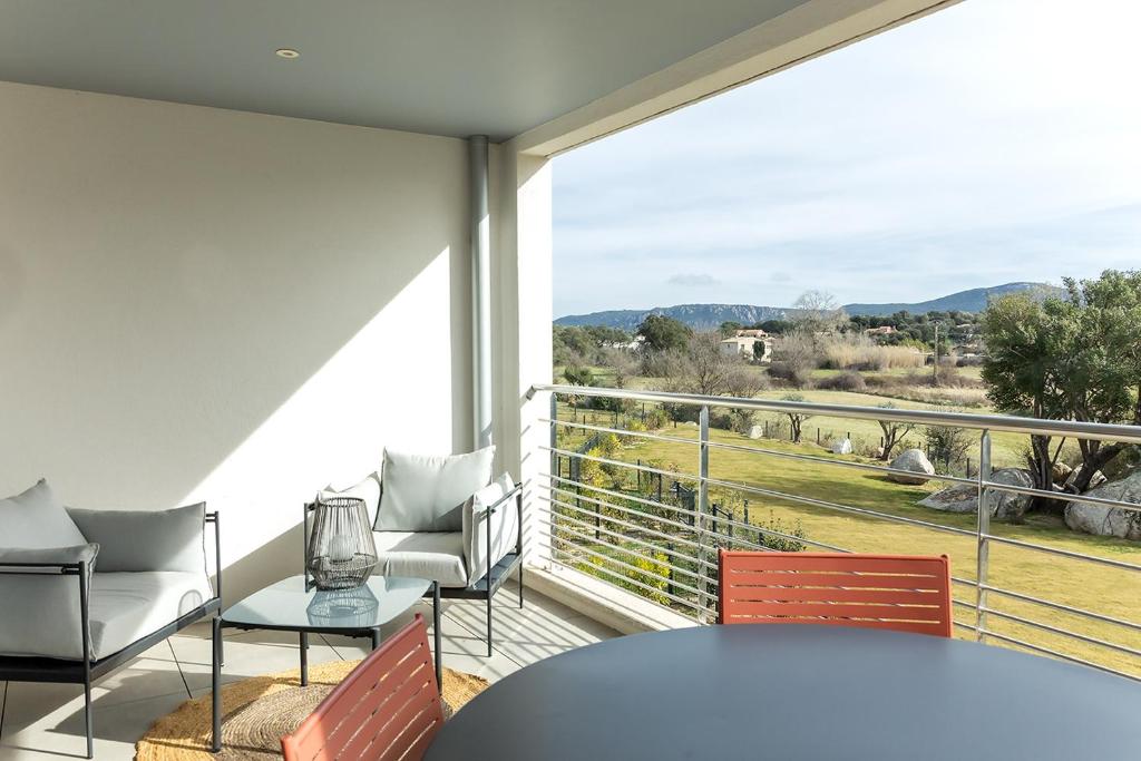 ポルト・ヴェッキオにあるFlaubert 17 - Domaine d'Arca - 4 persのバルコニー(テーブル、椅子付)、大きな窓が備わります。