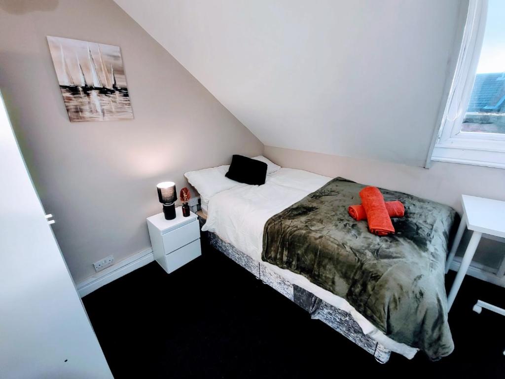 een kleine slaapkamer met een bed en een raam bij Burns Street - Stay Sleep Rest in Nottingham