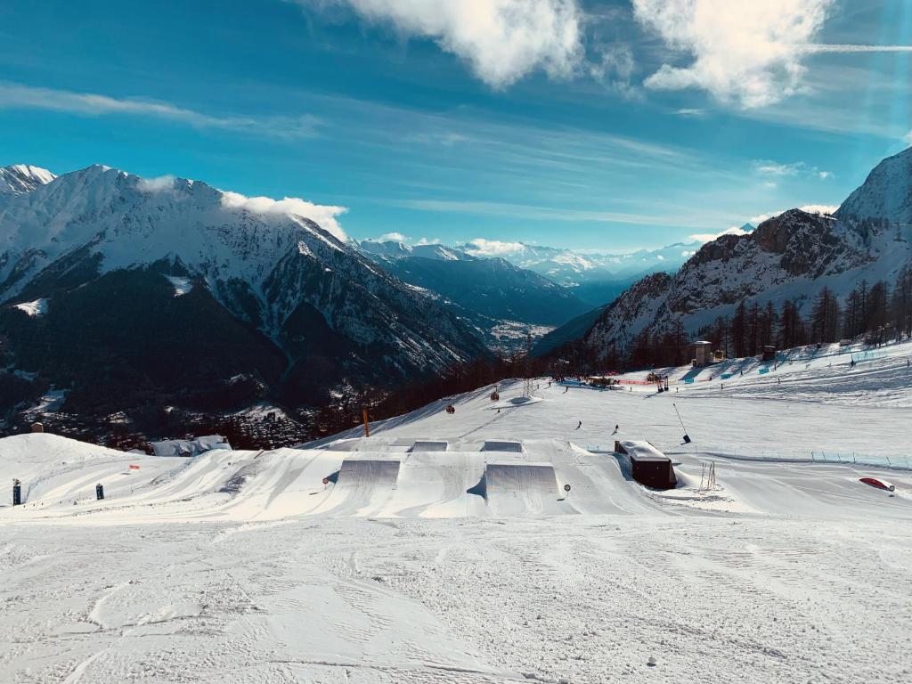 a snow covered slope with people skiing on a mountain at mansardacourmayeur in Courmayeur