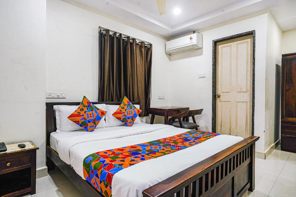 a bedroom with a bed with a colorful blanket on it at FabHotel Hamsa The Right Choice in Hyderabad