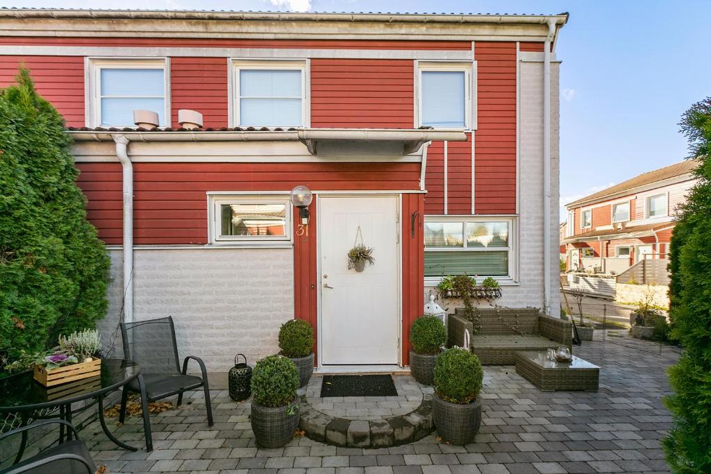 瓦倫蒂納的住宿－Stort tre plans hus i Vallentuna，白色的红色房子,有白色的门