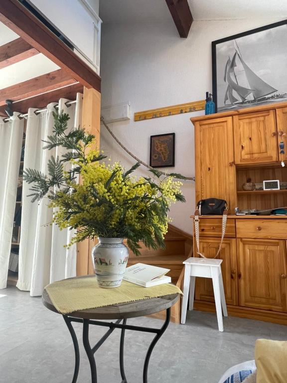 a table with a vase with a plant on it at LES MIMOSAS in Saint-Trojan-les-Bains