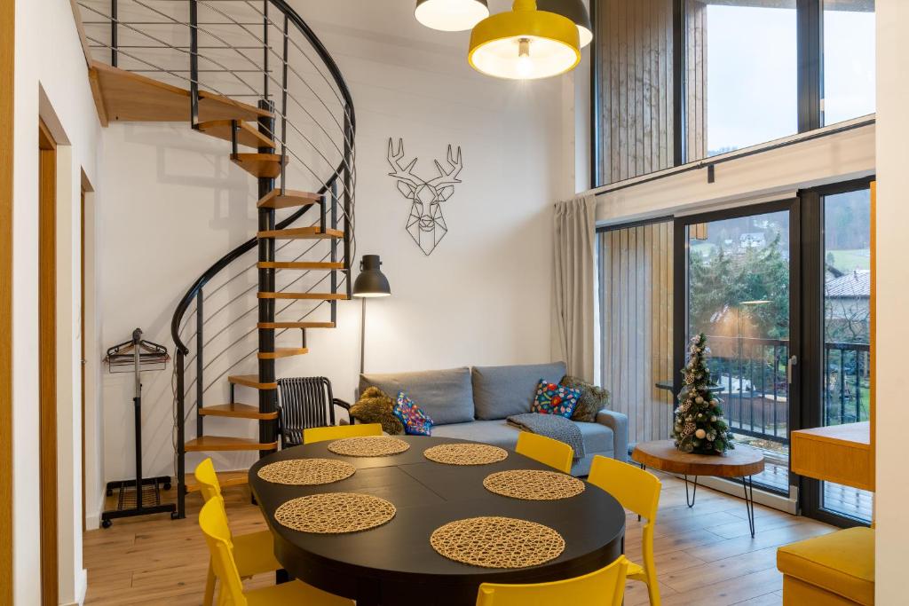 a living room with a table and yellow chairs at Widok na Gondolę – Sun&Sport in Szczyrk