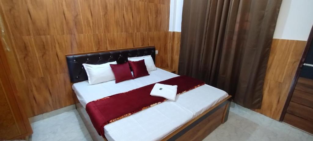 a bedroom with a bed with white and red pillows at Stay With Prarambha in Rishīkesh
